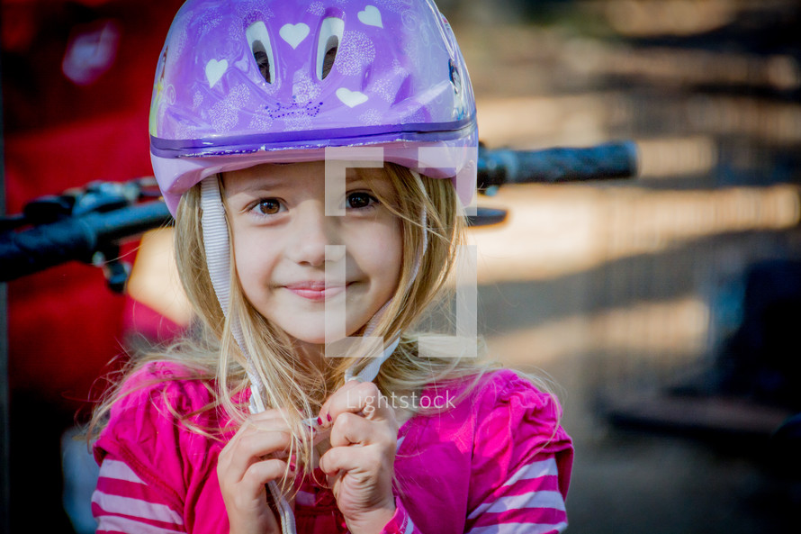 girl child wearing a bike helmet 