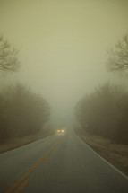 headlights through the fog on a highway