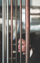 woman looking through metal bars 
