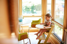 a toddler sitting in a highchair 