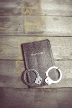 handcuffs on the cover of a Bible 