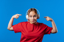 Positive woman listening to music on wireless headphones