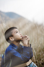 child looking up to God in prayer 