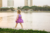 Girl walking by a lake.