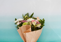 a bouquet of flowers in brown paper 