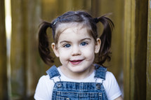 Little girl with pigtails in overalls