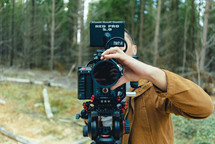 man with a video camera in a forest 