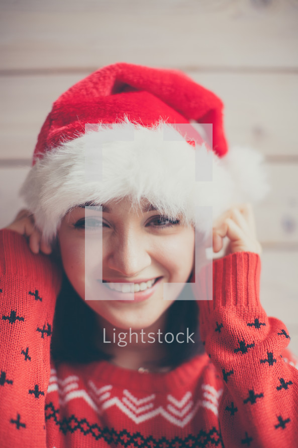 a woman in a Santa hat and Christmas sweater 