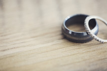 wedding bands on a wooden table top. 