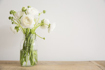 white flowers in a vase on a table 