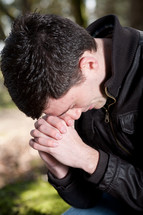 man with his head bowed in prayer