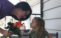 a little girl holding a bouquet of roses for mom 