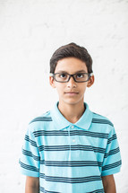 stoic face on a boy child with reading glasses 