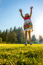 little girl jumping in the grass