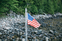 American flag on a rocky shore 