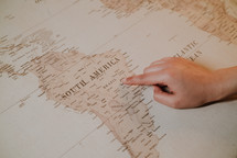 a finger pointing to a map 