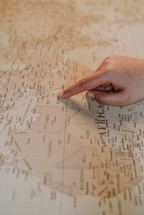 finger pointing to a map 
