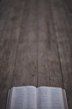 An open Bible on a wooden table