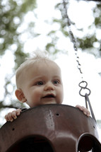 infant boy on a swing set 