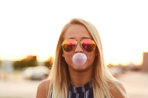 a woman blowing a bubble of bubble gum 