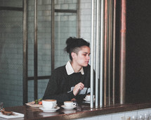a woman in a restaurant drinking coffee 