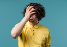 Worried man doing panic despair gesture, like no, I forgot. Disappointed guy feeling sorrow, regret, drama, failure, problems on blue background. High quality