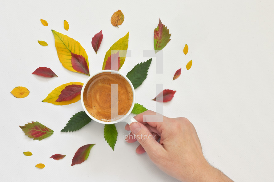 Espresso Coffee Cup with Autumn Leaves and Hand