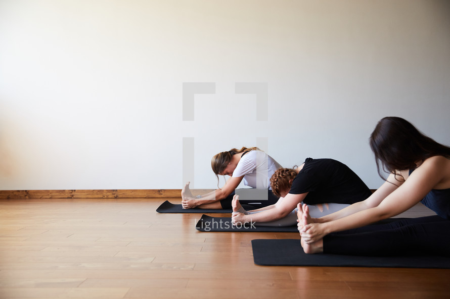 women stretching on yoga mats 