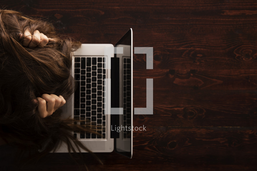 stressed girl in front of a laptop computer 