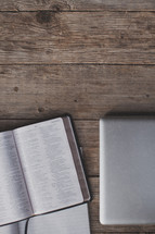 An open Bible, notebook and laptop