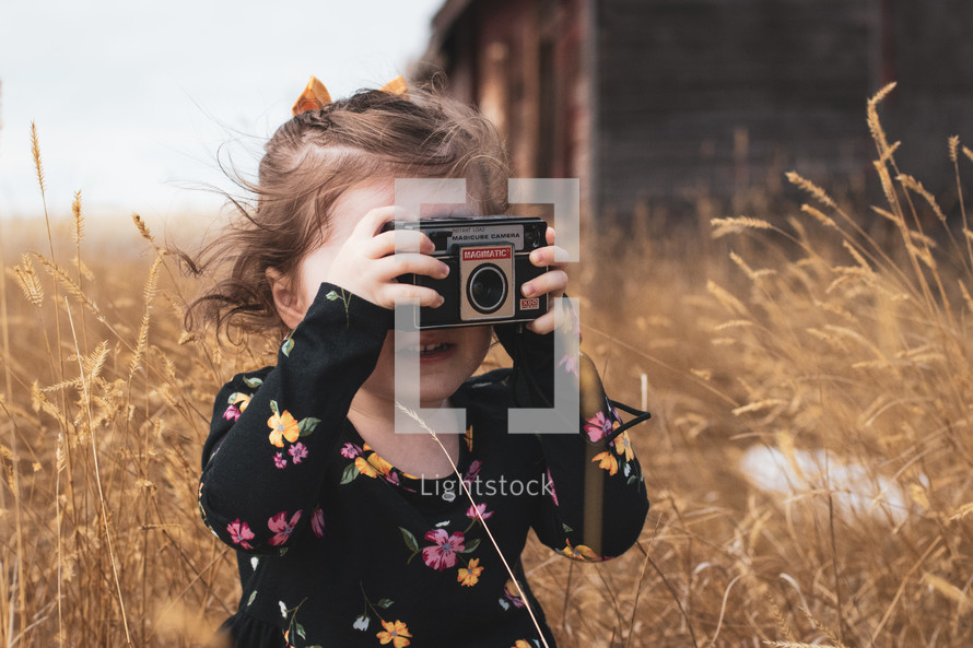 a child taking a picture with an old camera 