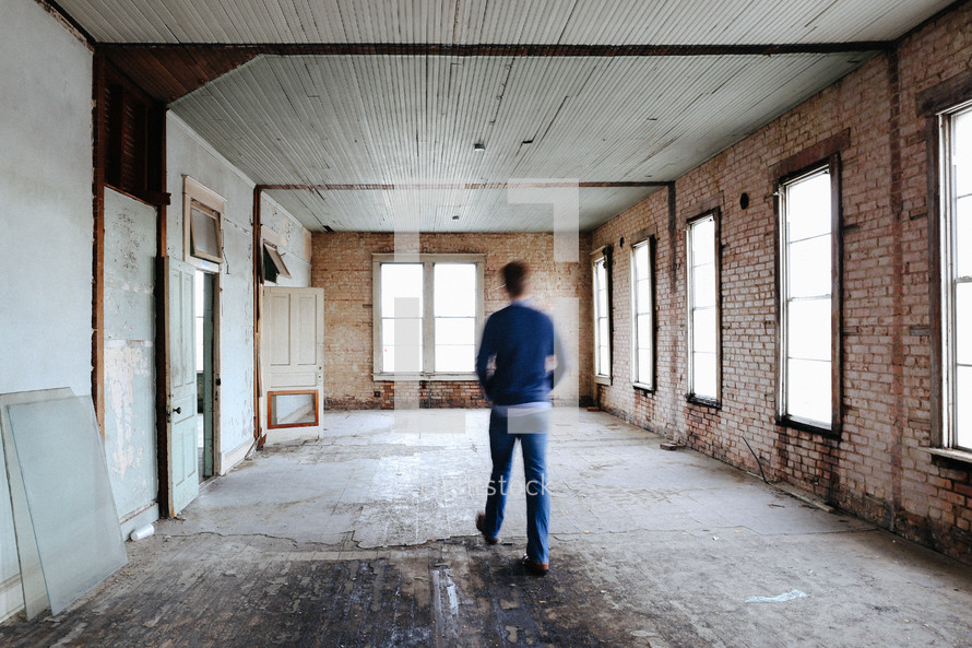 a man walking through a house that is being remodeled