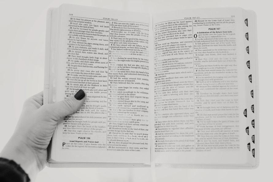 woman holding out an open Bible 