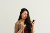 a woman reacting to something he read on his cellphone screen 