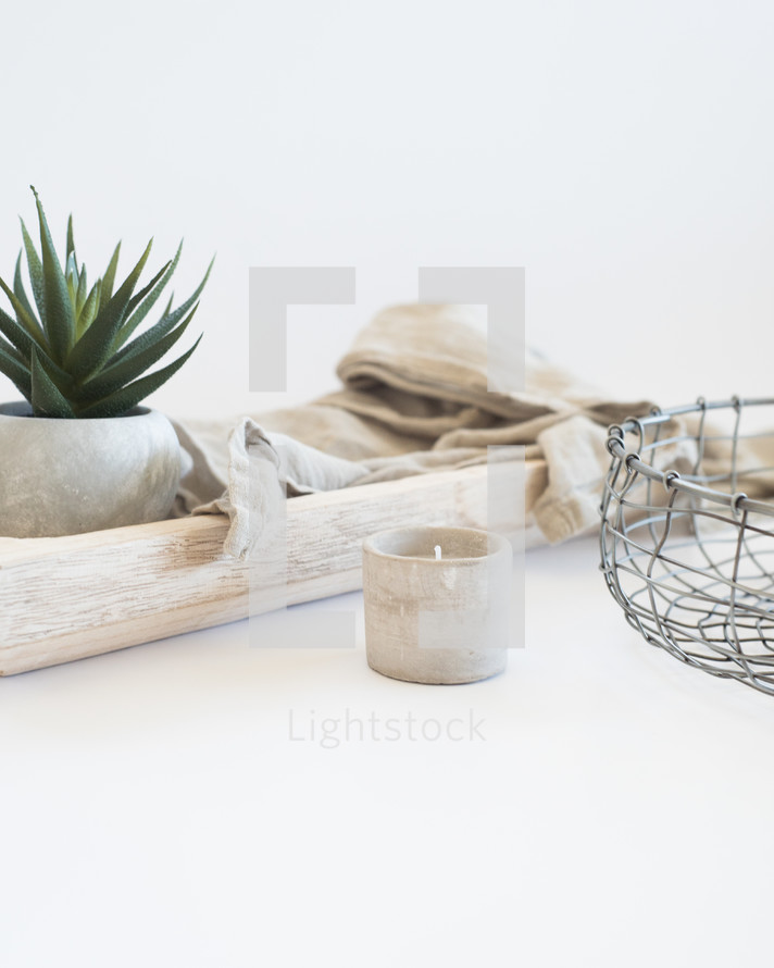 house plant, potted plant, wire basket, basket, linen, fabric, wood, tray, votive, candle, white background 