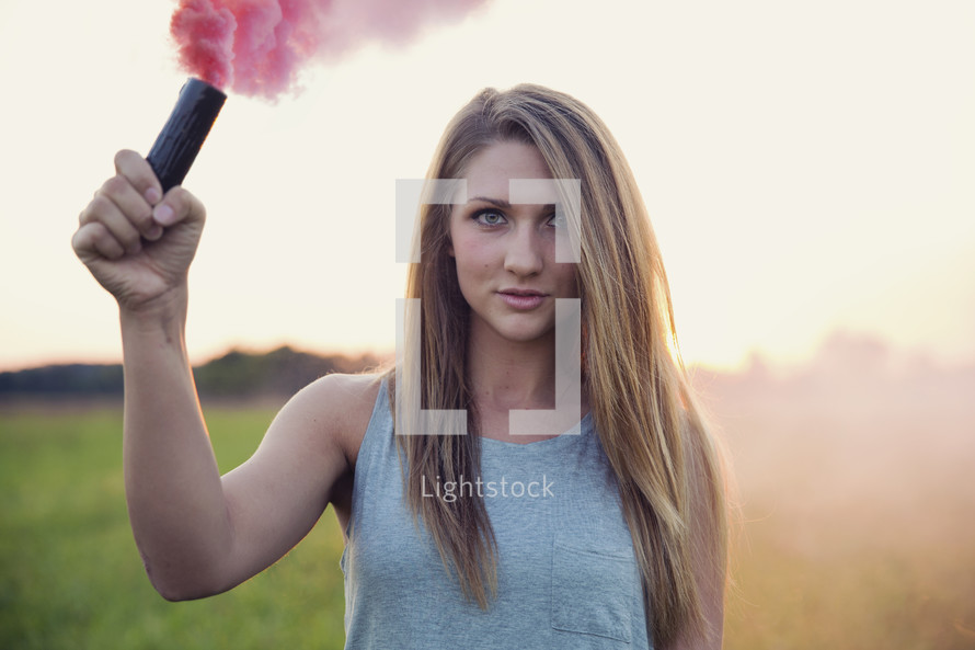 young woman holding a smoke flare 