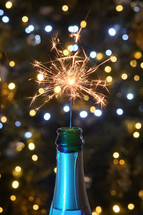 Champagne bottle with sparkler and bokeh lights