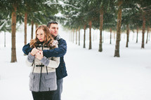 a couple standing in falling snow 