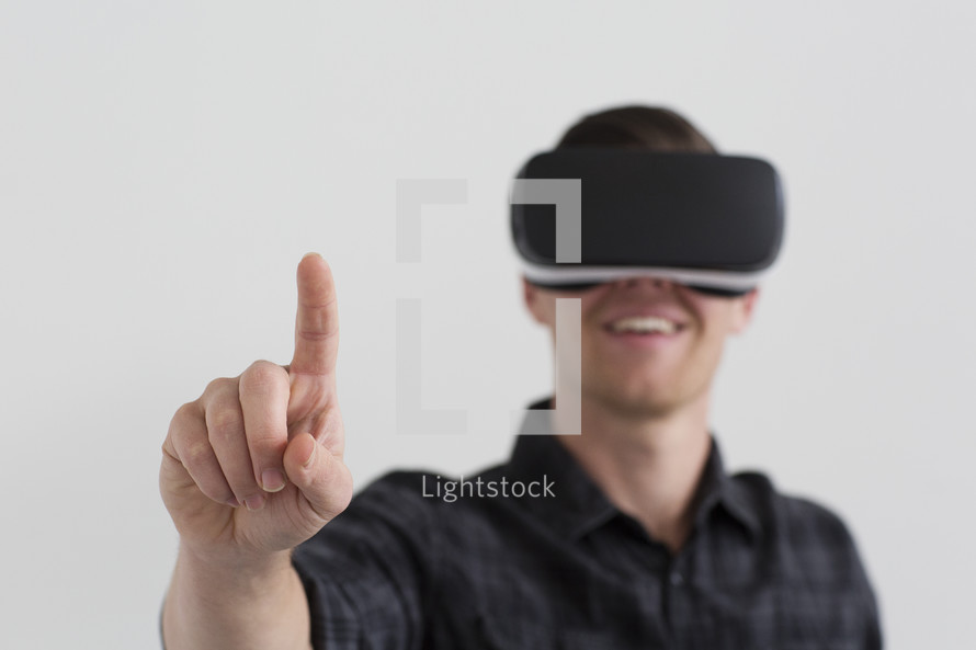 A man wearing 3d virtual reality glasses and holding his finger up.