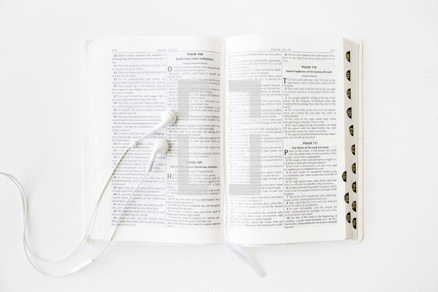 Ear phones on an open Bible.