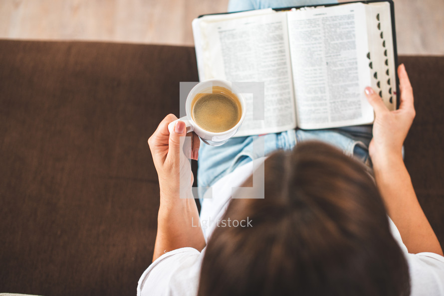 a woman reading the Bible and holding a coffee cup 
