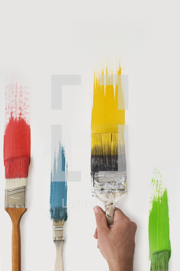 Paint brushes and colorful paint on a white canvas.