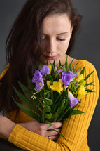 a young woman holding a bouquet of flowers 