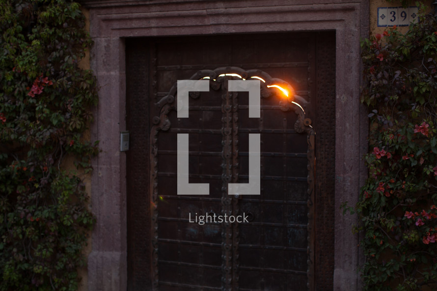 light peeking through the crack of a metal gate 