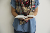 a torso of a woman holding a Bible 