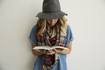 a woman in plaid shaw reading a Bible 