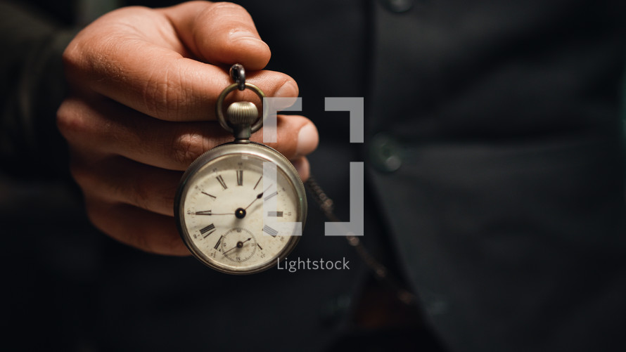 Man holds pocket watch in hand