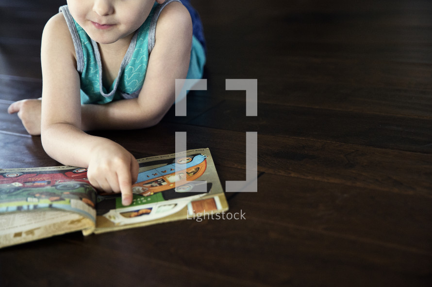 a toddler boy reading a Book 
