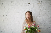 a woman holding a bouquet of tulips 