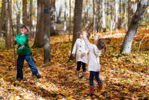 children playing in fall leaves 